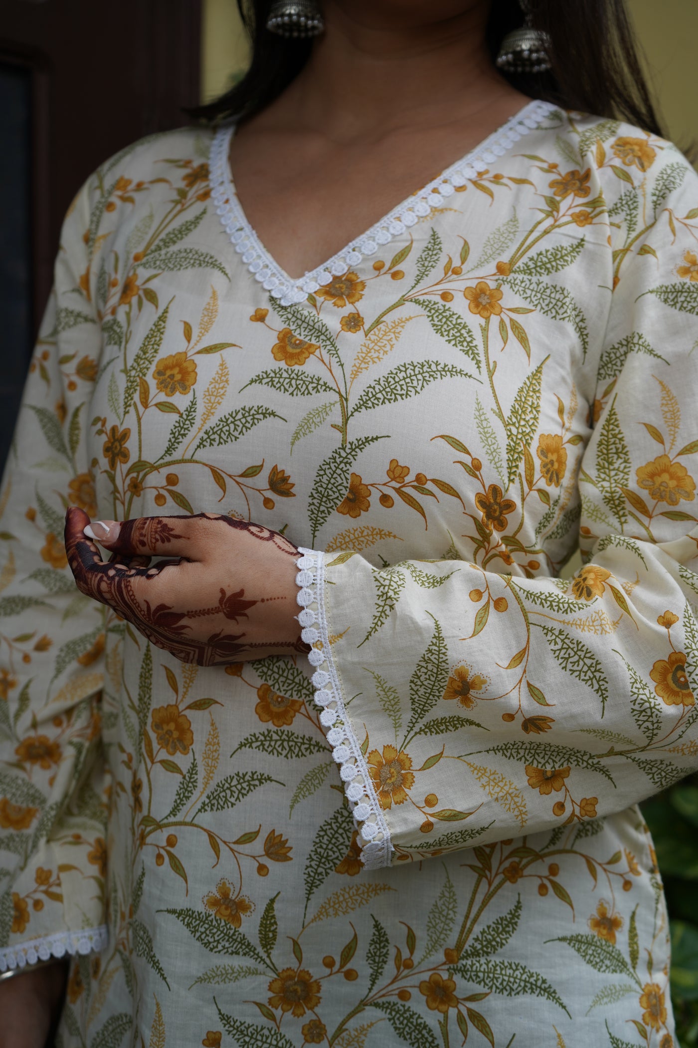Floral cotton kurti with yellow flower print, V-neck lace detailing, and bell sleeves – Vasanti by Pahraav