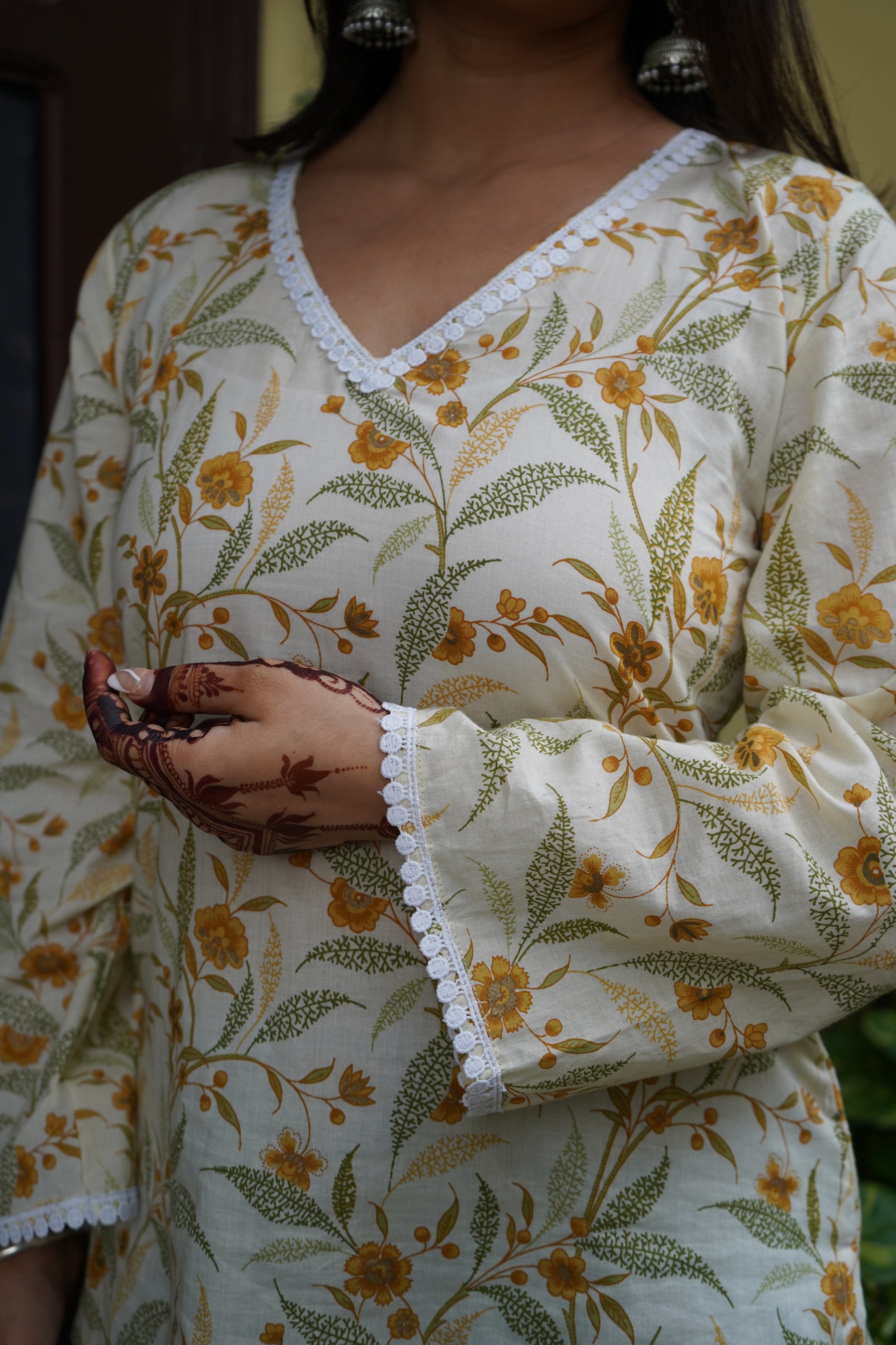 Floral cotton kurti with yellow flower print, V-neck lace detailing, and bell sleeves – Vasanti by Pahraav